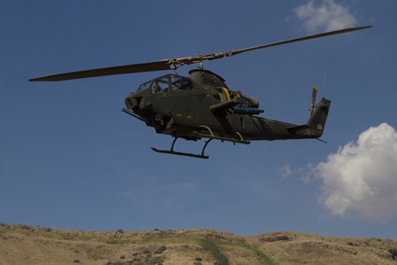 An AH-1F Tzefa of the Israeli Air Force flying over the Golan Heights, Israel by Ofer Zidon/Stocktrek Images art print