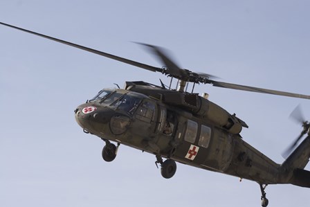 A UH-60 Blackhawk Medivac helicopter flies over Camp Warhorse by Terry Moore/Stocktrek Images art print