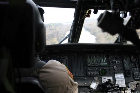 A UH-60 Blackhawk flies the River to an Unknown Village to Drop off a Care Package by Terry Moore/Stocktrek Images art print